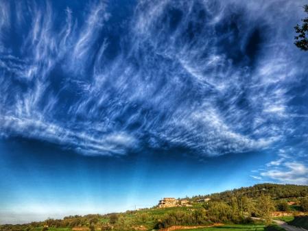 Postal de paisaje de payés, en Llobera, con el cielo artístico de la primavera.