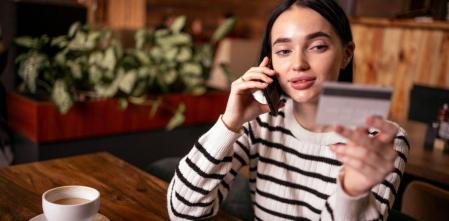 Una chica, a punto de pagar con tarjeta de débito en el extranjero