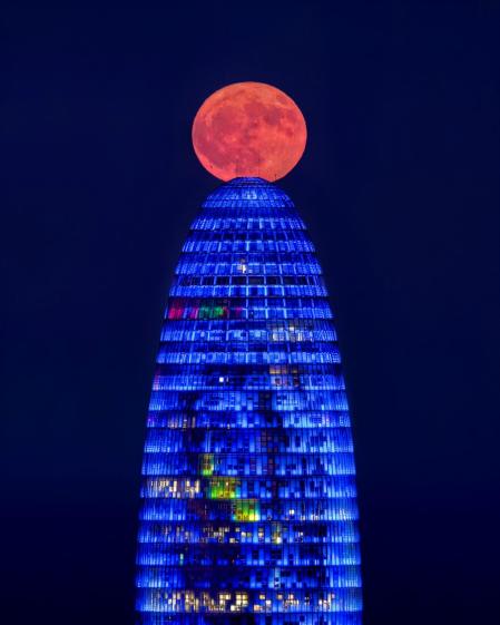 La luna saliendo del mar junto a Torre Glòries.