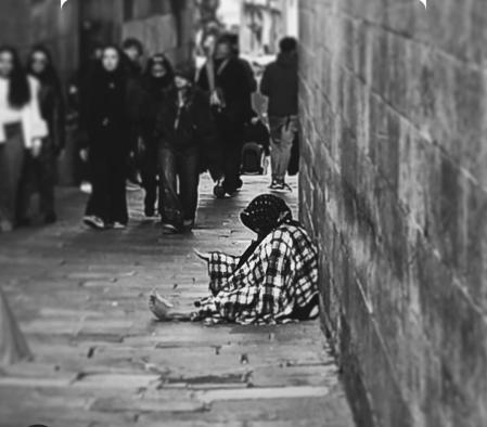 Una persona pidiendo limosna en las inmediaciones de la Catedral de Barcelona.