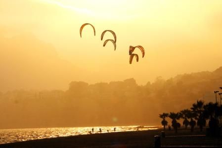 Practicando kitesurfing al atardecer en la playa de Calp.