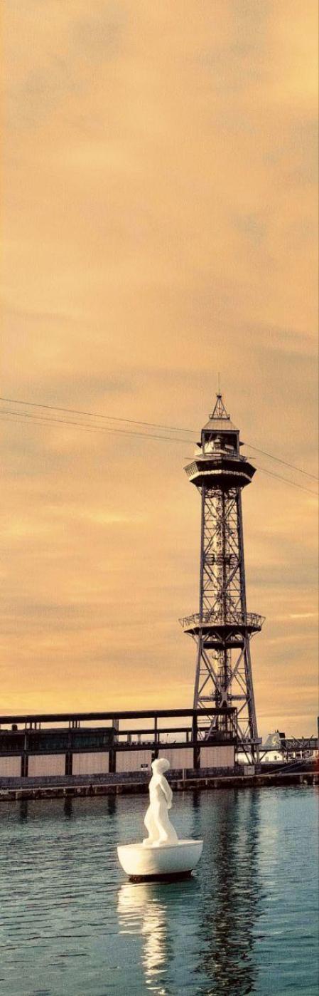 La Torre de Jaume I del puerto de Barcelon vigila una de las esculturas blancas flotantes 'Miraestels', diseñadas por el artista Robert Llimós.