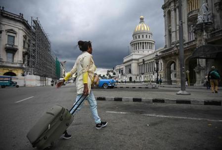 Una mujer acarreando una maleta frente al Capitolio Nacional de La Habana el 30 de enero 