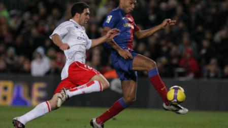 Henry remata el balón ante un rival