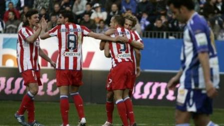 El holandés John Heitinga del Atlético de Madrid recibe la felicitación de sus compañeros tras el gol del empate en el partido disputado en La Rosaleda