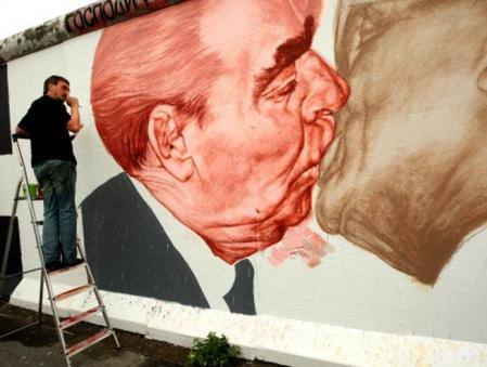 El artista ruso Dmitry Vrubel pinta el histórico muro de Berlín con las imágenes del ex líder soviético Leonid Brezhnev besándose con el ex líder comunista de Alemania Oriental Erich Honecker