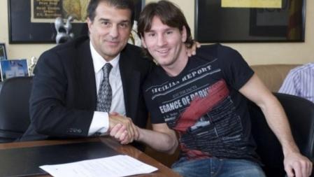El presidente del FC Barcelona, Joan Laporta y el delantero blaugrana, Leo Messi, encajan manos tras firmar la renovación del jugador hasta 2016