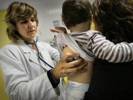 Una pediatra del centro de salud Guineueta atiende a un niño aquejado de los síntomas de gripe