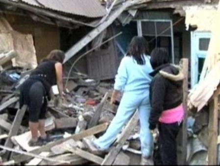 Un grupo de mujeres, ante las ruinas de un edificio derrumbado por el terremoto