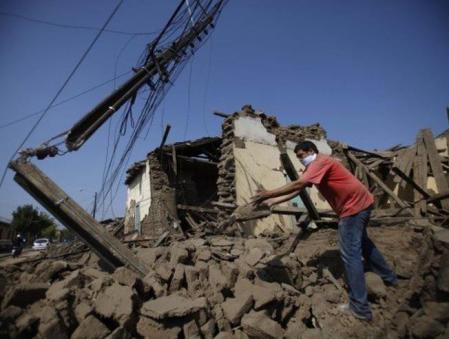 Un vecino de la ciudad de Talca camina entre los escombros