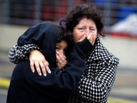 Una madre y su hija tratan de evitar los malos olores que se han originado por la descomposición de los cadáveres, tras el fuerte terremoto ocurrido en Chile