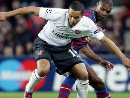 El defensa francés del FC Barcelona Eric Abidal (d) y el centrocampista del Arsenal, Theo Walcott luchan por el balón durante el partido de vuelta de cuartos de final de la Liga de Campeones que ambos equipos disputan en el estadio Camp Nou de Barcelona
