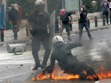 Unos agentes de la Policía antidisturbios son atacados con cócteles molotov durante un acto de protesta contra la política de austeridad del Gobierno griego en Atenas