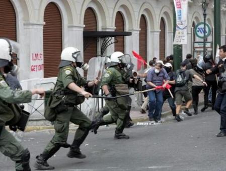 Unos agentes de la Policia antidisturbios cargan contra unos manifestantes durante un acto de protesta frente al Parlamento griego en Atenas