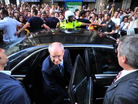 El presidente de la Generalitat José Montilla entra en su vehículo tras disolverse la cabezera de la manifestación mientras es abucheado por un grupo de asistentes