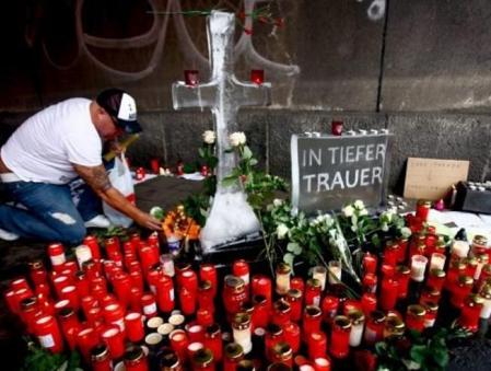 Un hombre enciende velas en la entrada del túnel, dónde un cartel resume el sentir compartido con un escueto 