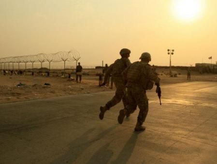 Dos soldados estadounidenses se preparan para subir a uno de los vehículos blindados para abandonar el sur Iraq