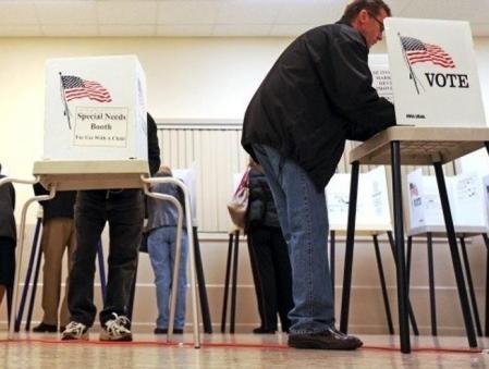 Varias personas preparan sus votos en un colegio electoral de Highwood