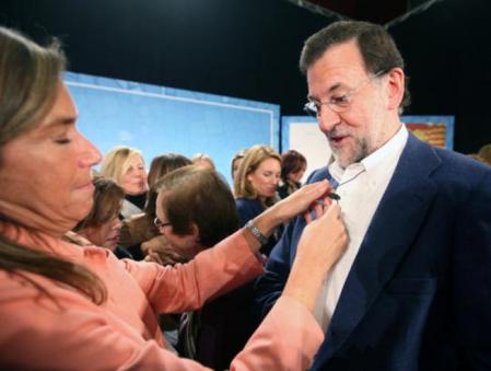 Ana Mato acondiciona el micrófono del presidente del PP, Mariano Rajoy, en el mitin del PPC en L'Hospitalet de Llobregat