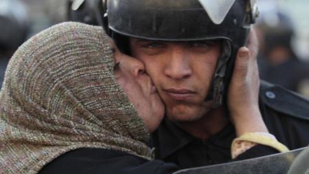 Una manifestante egipcia besa a uno de los policías que vigilan las protestas en la plaza Tahrir