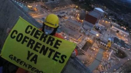 Un activista muestra una pancarta pidiendo el cierre de la central de Confrentes en una acción de Greenpeace