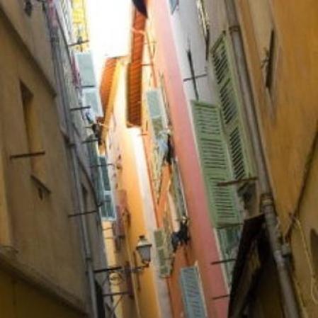 Una calle estrecha calle en el Viejo Niza con edificios de colores brillantes y ropa tendida