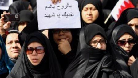 Un grupo de mujeres que ha participado hoy en los funerales por los muertos de la represión muestra una pancarta en la que se lee: 