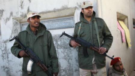 Dos soldados leales a Gadafi hacen guardia a las afueras de un cuartel en Trípoli