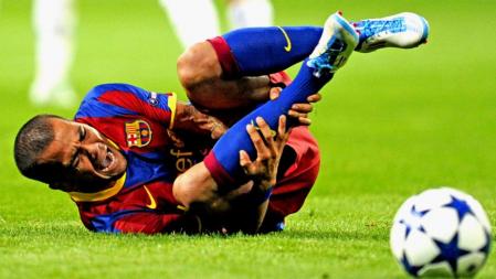 El lateral brasileño Daniel Alves se retuerce del dolor tras la violenta entrada de Pepe, central portugués del Real Madrid