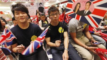 Jóvenes chinos siguen la boda del príncipe Guillermo y Catalina, duques de Cambridge, en un centro comercial en Kwun Tong, Hong Kong
