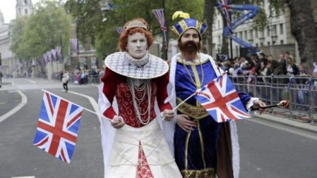 Una pareja desifla disfrazada de pareja real mientras la multitud espera el comienzo del enlace del príncipe Guillermo y Kate Middleton en Whitehall