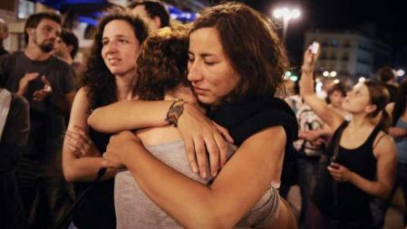 Dos mujeres se abrazan en la última noche de la acampada de los 'indignados' en la Puerta del Sol