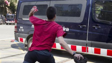 Un individuo lanza una lata de cerveza contra un furgón de la policía de los Mossos d'Esquadra