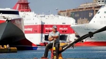 Un trabajador del Puerto del Pireo, en Atenas, sin trabajo observa los buques atracados por la huelga general en Grecia