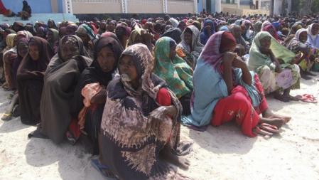 Mujeres somalís del sur del país esperan sentadas a recibir ayuda en el campo de refugiados de Mogadiscio