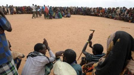 Refugiados somalís que cruzaron recientemente la frontera con el sur de Etiopía, en el punto de tránsito del campo de refugiados Dodo Alo esperando que les llamen por su nombre para empezar el proceso en el que recibirán la tarjeta de refugiado que les permita recibir ayuda alimentaria