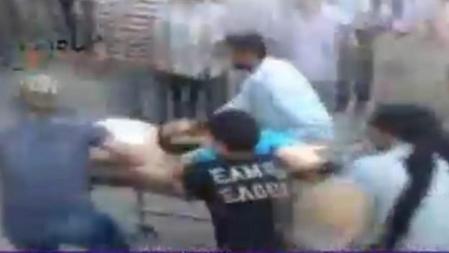 Imagen tomada del canal de televisión Al Arabiya de varios manifestantes sirios que evacúan a un hombre herido tras la operación del ejército sirio en la ciudad de Hama