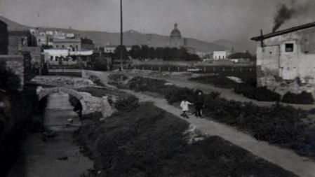 El Rec Comtal a su paso por la masia de Can Travé, con la cúpula de la parroquia en el fondo