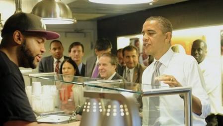 El presidente de los EE.UU., Barack Obama (d), pide una hamburguesa en un establecimiento de comida en las proximidades del Capitolio de Washington D.C., EE.UU. acompañado de varios asesores