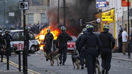 Policía antidisturbios se despliega en el conflictivo barrio de Hackney, al norte de Londres (Reino Unido), en el tercer día de confrontaciones entre la policía y un grupo de jóvenes que saquearon tiendas y atacaron autobuses. Los disturbios se han propagado por varios barrios de Londres desde que en la madrugada del domingo se desató en Tottenham (norte de Londres) una grave ola de violencia que ha causado daños superiores a 115 millones de euros