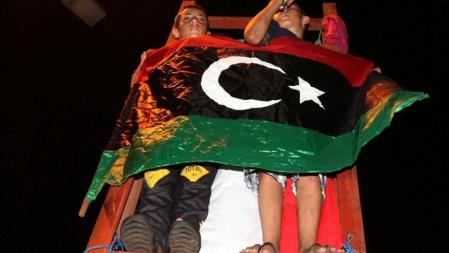 Dos niños aguantan una bandera rebelde en un suburbio de Trípoli