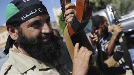 Un combatiente rebelde posa con su arma en una calle de Tripoli