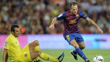 Andrés Iniesta deja sentado a Carlos Marchena durante el encuentro entre el Barça y el Villarreal en el Camp Nou