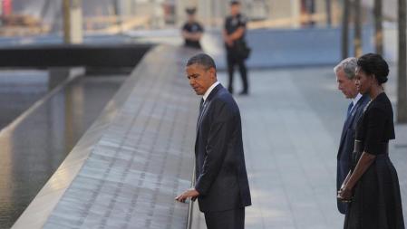 Obama contempla los nombres de las víctimas en la placa conmemorativa situada en el World Trade Center, ante la mirada de su esposa y del ex presidente George W. Bush