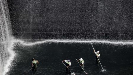 Últimos preparativos. Unos hombres limpian la cascada del memorial por las víctimas de las torres, ayer en Nueva York