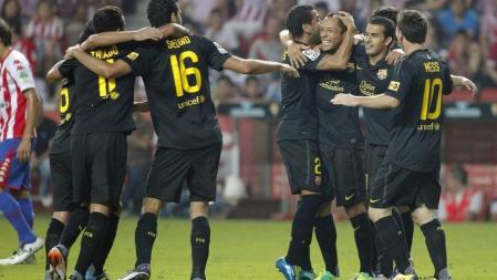 Los jugadores del FC Barcelona celebran el primer gol del equipo marcado por el brasileño Adriano Correia (3d), ante el Sporting, durante el partido correspondiente a la séptima jornada de la Liga en Primera División que ambos equipos disputan en el estadio El Molinón