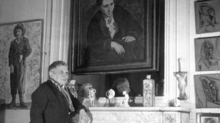 Gertrude Stein (1874-1946) posa frente un retrato realizado por Picasso