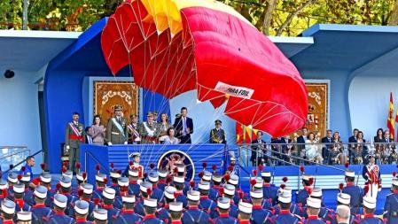 Un paracaidista, ante el palco de autoridades del desfile militar de la Fiesta Nacional, en Madrid