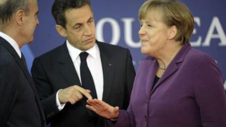 Angela Merkel y Nicolas Sarkozy se saludan a su llegada a Cannes.