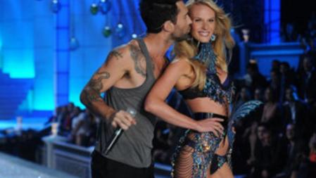 El cantante de Maroon 5, Adam Levine, besa a una de las modelos durante su actuación